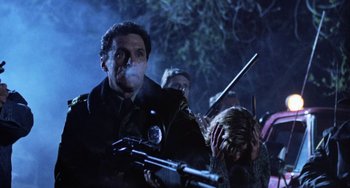 Movie still from “Halloween 5: The Revenge of Michael Myers” (1989), directed by Dominique Othenin-Girard – A group of people standing next to each other holding guns; Medium shot, Low angle