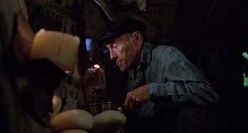 Movie still from “Halloween 5: The Revenge of Michael Myers” (1989), directed by Dominique Othenin-Girard – An old man is cooking some food in the dark; Medium shot, Low angle