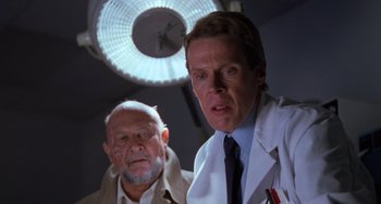 Movie still from “Halloween 5: The Revenge of Michael Myers” (1989), directed by Dominique Othenin-Girard – Two men in lab coats standing next to each other in front of a lamp; Close Up shot, Low angle