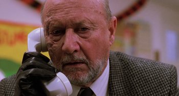 Movie still from “Halloween 5: The Revenge of Michael Myers” (1989), directed by Dominique Othenin-Girard – An older man with a beard and a mustache is talking on a phone; Close Up shot, Low angle