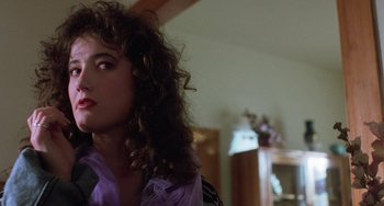 Movie still from “Halloween 5: The Revenge of Michael Myers” (1989), directed by Dominique Othenin-Girard – A young woman with long curly brown hair wearing a purple shirt; Close Up shot, Over the shoulder angle