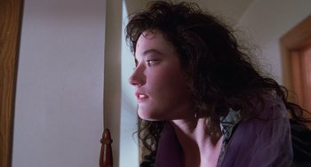 Movie still from “Halloween 5: The Revenge of Michael Myers” (1989), directed by Dominique Othenin-Girard – A woman with curly hair is looking at a chess piece; Close Up shot, Low angle