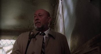 Movie still from “Halloween 5: The Revenge of Michael Myers” (1989), directed by Dominique Othenin-Girard – An older man wearing a suit and tie with an umbrella; Close Up shot, Low angle