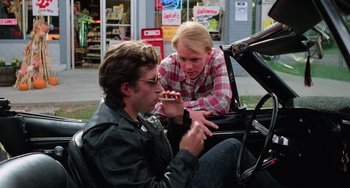 Movie still from “Halloween 5: The Revenge of Michael Myers” (1989), directed by Dominique Othenin-Girard – A man and a woman sitting in the back of a car; Medium shot, Over the shoulder angle