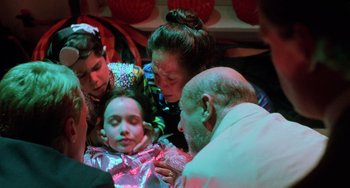 Movie still from “Halloween 5: The Revenge of Michael Myers” (1989), directed by Dominique Othenin-Girard – A group of people gathered around a young girl; Medium shot, High angle
