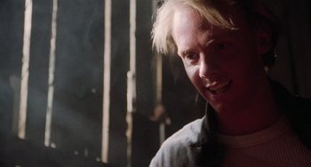 Movie still from “Halloween 5: The Revenge of Michael Myers” (1989), directed by Dominique Othenin-Girard – A man with blonde hair is smiling for the camera; Close Up shot, Over the shoulder angle