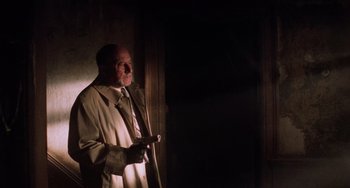 Movie still from “Halloween 5: The Revenge of Michael Myers” (1989), directed by Dominique Othenin-Girard – An older man in a white coat holding a remote control; Medium shot, Low angle