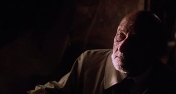 Movie still from “Halloween 5: The Revenge of Michael Myers” (1989), directed by Dominique Othenin-Girard – An old man with a beard is sitting in a dark room; Close Up shot, Over the shoulder angle