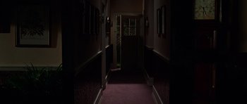 Movie still from “Halloween H20: 20 Years Later” (1998), directed by Steve Miner – A dark hallway with a door open and a light shining on it; Wide shot, High angle
