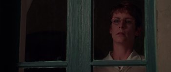 Movie still from “Halloween H20: 20 Years Later” (1998), directed by Steve Miner – A woman wearing glasses looking out of a window; Close Up shot, Over the shoulder angle