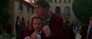 Movie still from “Halloween H20: 20 Years Later” (1998), directed by Steve Miner – A man and a woman are hugging in a crowd of people; Medium shot, Low angle