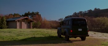 Movie still from “Halloween H20: 20 Years Later” (1998), directed by Steve Miner – An old truck parked in the grass near a building; Extreme Wide shot, Low angle
