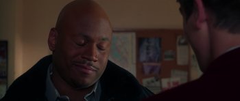 Movie still from “Halloween H20: 20 Years Later” (1998), directed by Steve Miner – A man with a bald head sitting in front of a painting; Close Up shot, Over the shoulder angle