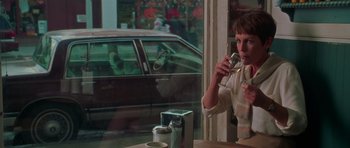 Movie still from “Halloween H20: 20 Years Later” (1998), directed by Steve Miner – A woman sitting in front of a window holding a wine glass; Medium shot, Over the shoulder angle