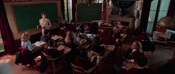 Movie still from “Halloween H20: 20 Years Later” (1998), directed by Steve Miner – A group of people sitting at a table in front of a blackboard; Wide shot, High angle