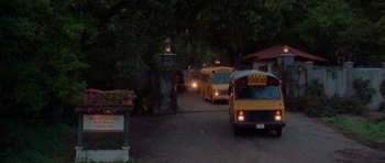 Movie still from “Halloween H20: 20 Years Later” (1998), directed by Steve Miner – A line of school buses driving down a street; Extreme Wide shot, High angle