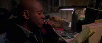 Movie still from “Halloween H20: 20 Years Later” (1998), directed by Steve Miner – A man talking on a phone while sitting at a desk; Close Up shot, High angle