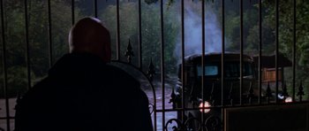 Movie still from “Halloween H20: 20 Years Later” (1998), directed by Steve Miner – A man standing in front of an iron gate; Wide shot, Over the shoulder angle