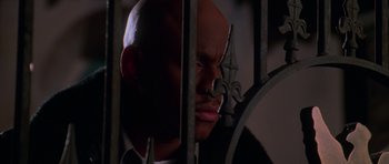 Movie still from “Halloween H20: 20 Years Later” (1998), directed by Steve Miner – A bald man with a mustache is behind bars; Close Up shot, Low angle