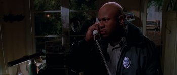 Movie still from “Halloween H20: 20 Years Later” (1998), directed by Steve Miner – A man talking on a phone while standing in front of a window; Medium shot, High angle