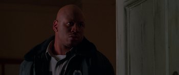 Movie still from “Halloween H20: 20 Years Later” (1998), directed by Steve Miner – A man with a bald head is standing by a door; Close Up shot, Low angle