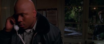 Movie still from “Halloween H20: 20 Years Later” (1998), directed by Steve Miner – A bald man in a black jacket and a tie; Close Up shot, High angle