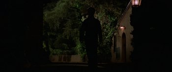 Movie still from “Halloween H20: 20 Years Later” (1998), directed by Steve Miner – A man standing in the middle of a street at night; Wide shot, Low angle