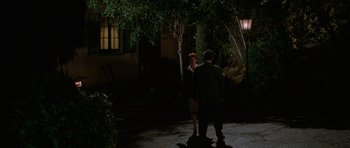 Movie still from “Halloween H20: 20 Years Later” (1998), directed by Steve Miner – A man and a woman standing on a sidewalk at night; Wide shot, High angle