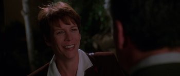 Movie still from “Halloween H20: 20 Years Later” (1998), directed by Steve Miner – A woman smiling at the camera while sitting in a chair; Close Up shot, Over the shoulder angle