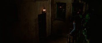 Movie still from “Halloween H20: 20 Years Later” (1998), directed by Steve Miner – A dark room with a light shining on the wall; Wide shot, High angle