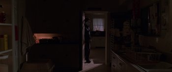 Movie still from “Halloween H20: 20 Years Later” (1998), directed by Steve Miner – A man standing in a dark kitchen at night; Wide shot, Low angle