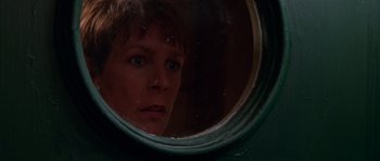 Movie still from “Halloween H20: 20 Years Later” (1998), directed by Steve Miner – A person looking through a round window; Close Up shot, Low angle