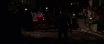 Movie still from “Halloween H20: 20 Years Later” (1998), directed by Steve Miner – A man is walking down the street at night; Wide shot, High angle