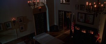 Movie still from “Halloween H20: 20 Years Later” (1998), directed by Steve Miner – A man standing in a dark room next to a door way; Wide shot, High angle