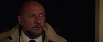 Movie still from “Halloween II” (1981), directed by Rick Rosenthal – A man with a bald head and a beard wearing a tie; Close Up shot, Low angle