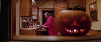 Movie still from “Halloween II” (1981), directed by Rick Rosenthal – An older woman in a pink robe in a kitchen; Medium shot, Low angle
