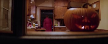 Movie still from “Halloween II” (1981), directed by Rick Rosenthal – A woman in a pink bathrobe standing in a kitchen; Wide shot, High angle