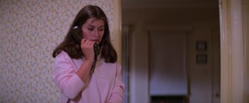 Movie still from “Halloween II” (1981), directed by Rick Rosenthal – A woman talking on a phone while standing next to a wall; Close Up shot, High angle