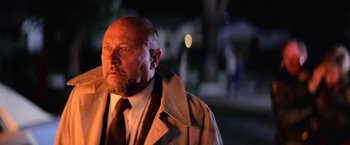 Movie still from “Halloween II” (1981), directed by Rick Rosenthal – An older man wearing a trench coat and a tie; Close Up shot, Low angle