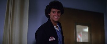Movie still from “Halloween II” (1981), directed by Rick Rosenthal – A young man smiling for the camera in front of a wall; Close Up shot, Low angle