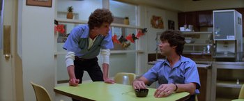 Movie still from “Halloween II” (1981), directed by Rick Rosenthal – Two men sitting at a table talking to each other; Medium shot, Low angle