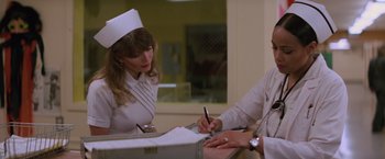 Movie still from “Halloween II” (1981), directed by Rick Rosenthal – A nurse writing on a piece of paper next to a patient; Medium shot, Low angle