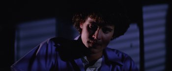 Movie still from “Halloween II” (1981), directed by Rick Rosenthal – A man with curly brown hair wearing a purple jacket; Close Up shot, Low angle