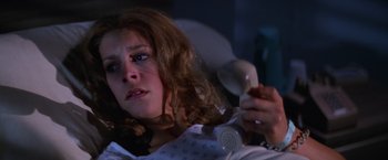 Movie still from “Halloween II” (1981), directed by Rick Rosenthal – A woman sitting in a bed holding a phone; Close Up shot, High angle