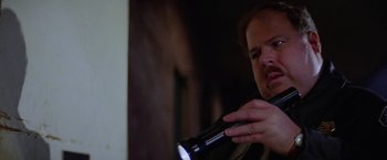 Movie still from “Halloween II” (1981), directed by Rick Rosenthal – A man holding a flashlight in his hand; Close Up shot, Low angle