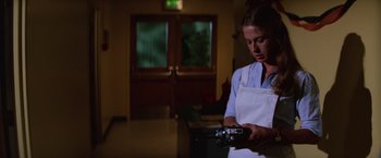 Movie still from “Halloween II” (1981), directed by Rick Rosenthal – A woman in a white apron is holding a camera; Medium shot, Low angle