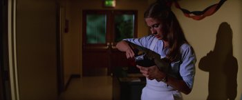 Movie still from “Halloween II” (1981), directed by Rick Rosenthal – A woman holding a cell phone in her hand; Medium shot, Low angle