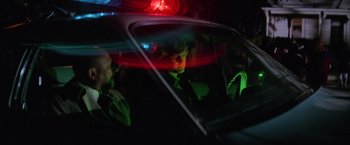 Movie still from “Halloween II” (1981), directed by Rick Rosenthal – A police officer sitting in the back of a patrol car at night; Medium shot, Over the shoulder angle