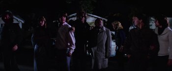 Movie still from “Halloween II” (1981), directed by Rick Rosenthal – A group of people standing in the dark outside; Wide shot, Low angle