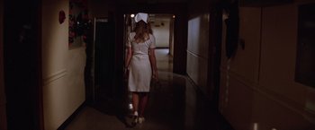 Movie still from “Halloween II” (1981), directed by Rick Rosenthal – A woman walking down a hall way wearing a white dress; Wide shot, Low angle